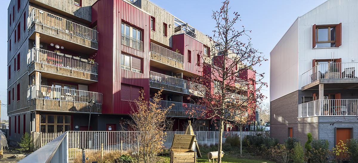 photo montrant des bâtiments utilisant du bois, on voit un petit jardin en premier plan